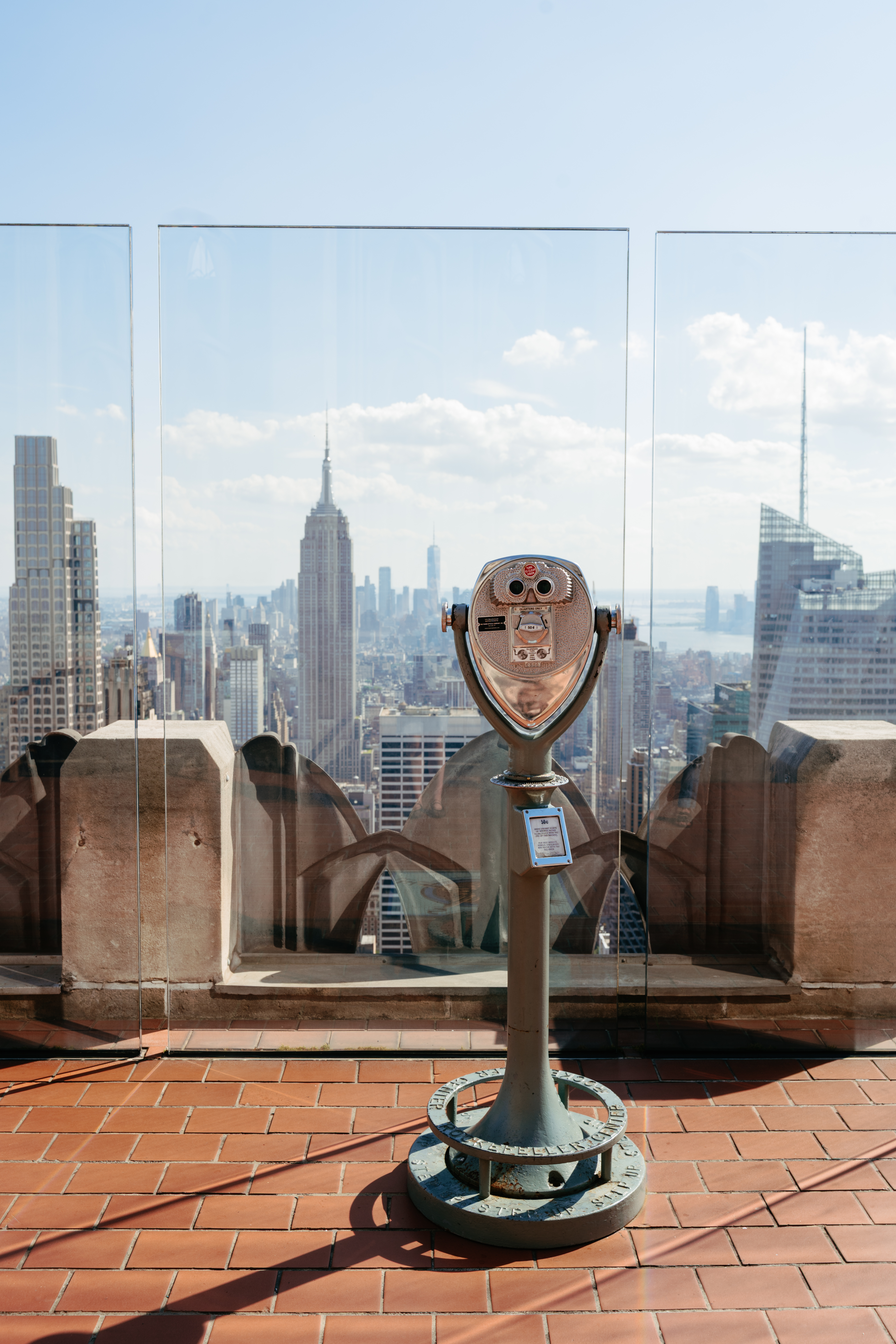 Fernglas auf der Aussichtsplattform Top of the Rock mit dem Empire State Building und der Skyline von Manhattan im Hintergrund