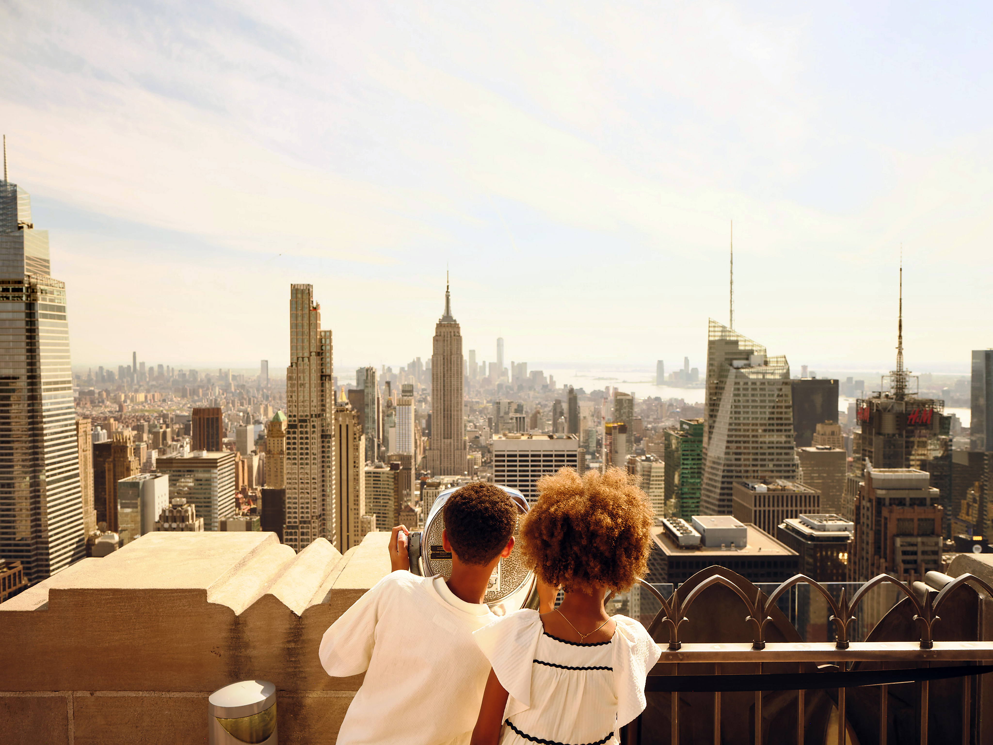 Kinder genießen vom Top of the Rock den Panoramablick auf das Empire State Building und Midtown Manhattan