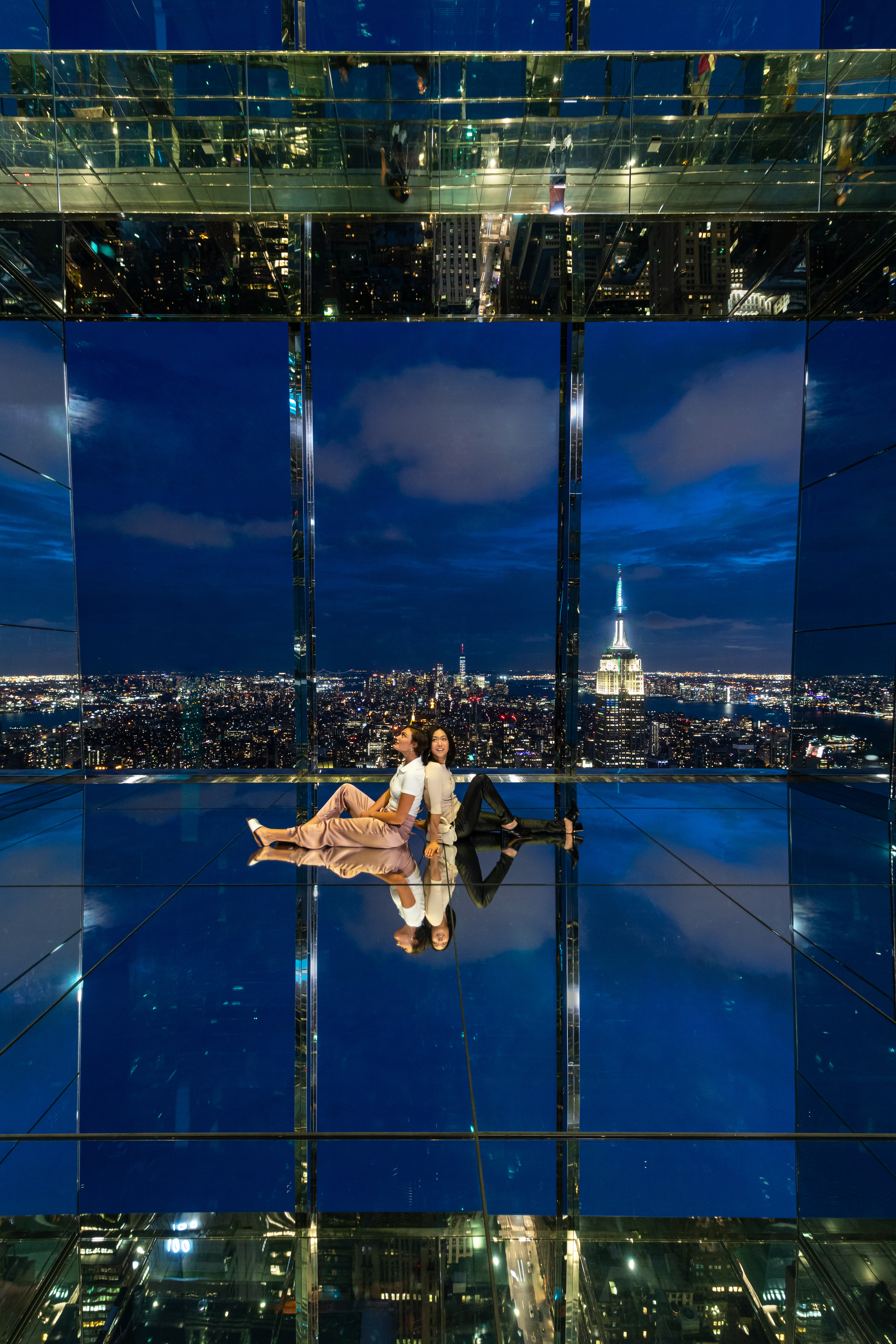 Verspiegelter Erlebnisraum im SUMMIT One Vanderbilt bei Nacht mit Blick auf das Empire State Building