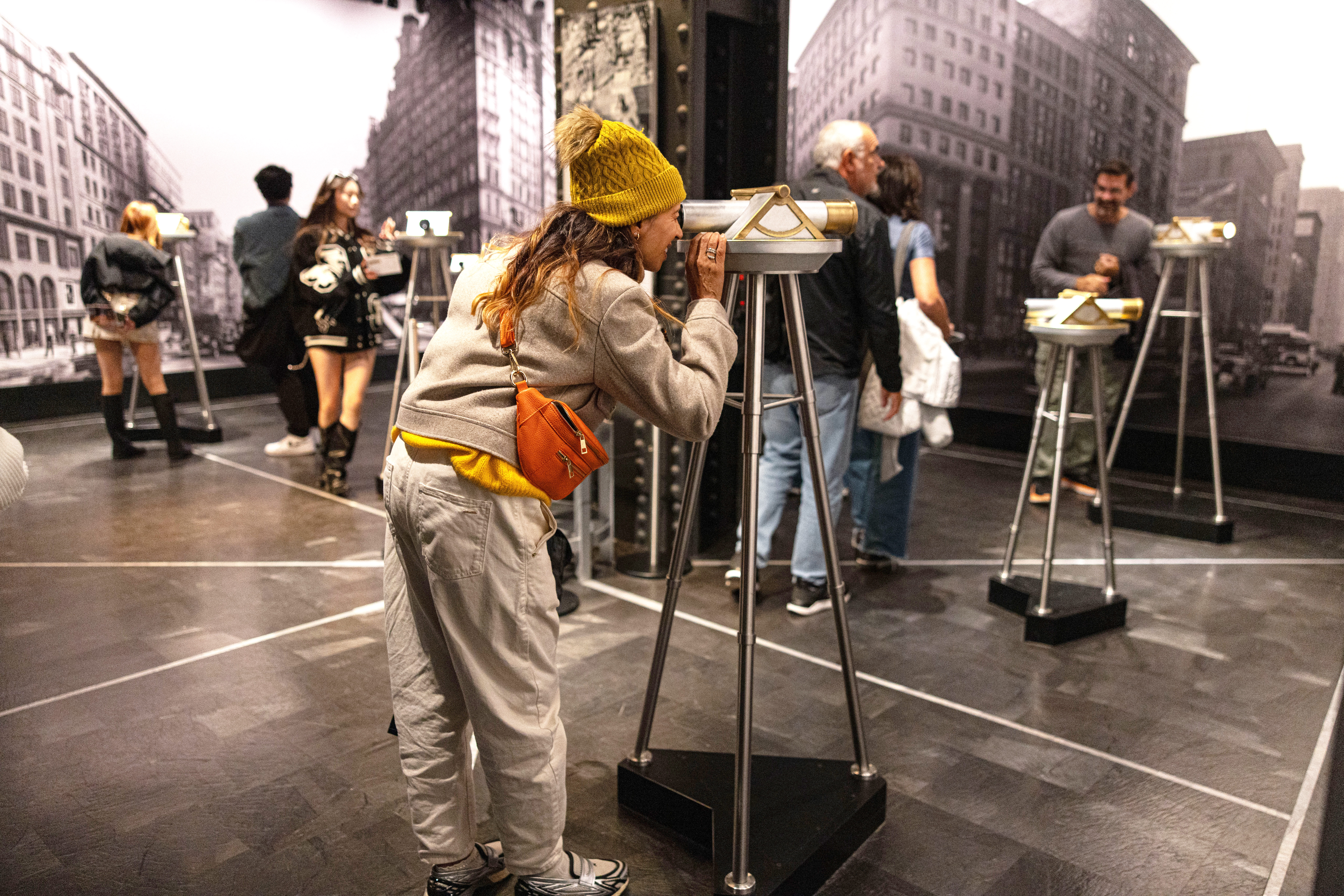 Besucherin schaut durch ein historisches Fernrohr in der Ausstellung zur Geschichte des Empire State Buildings