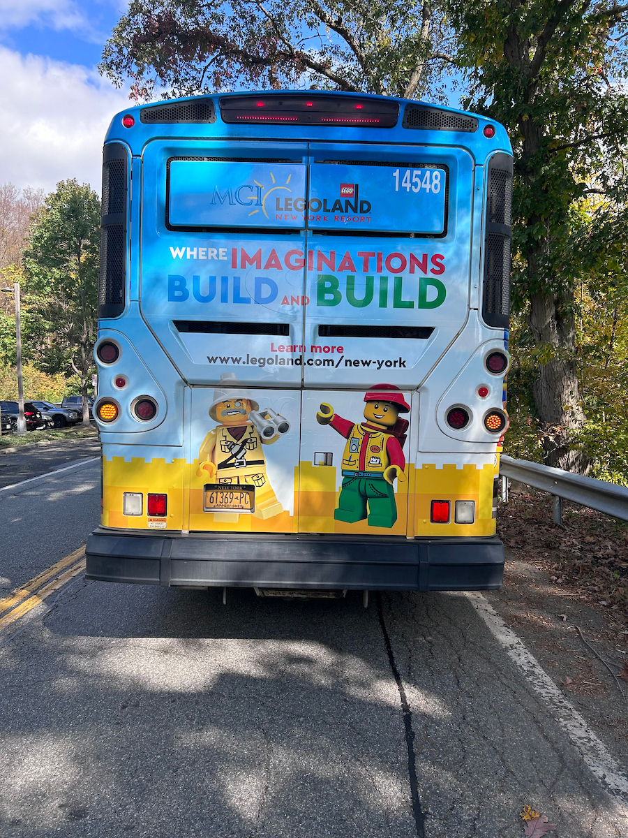 Rückansicht eines bunt gestalteten Busses mit Werbung für das LEGOLAND New York Resort