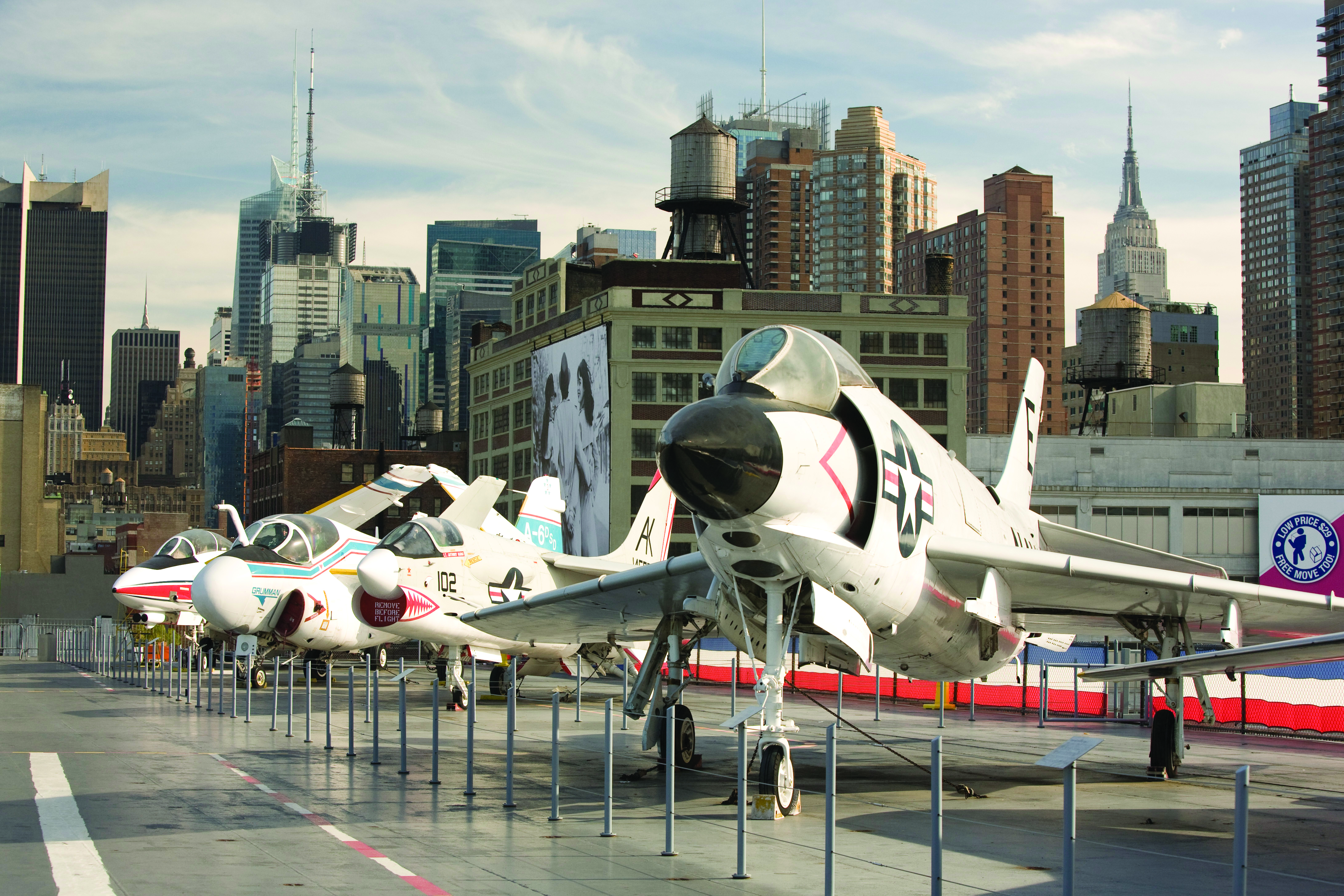 Historische Militärflugzeuge auf dem Flugdeck des Intrepid Sea, Air & Space Museum mit Manhattan im Hintergrund
