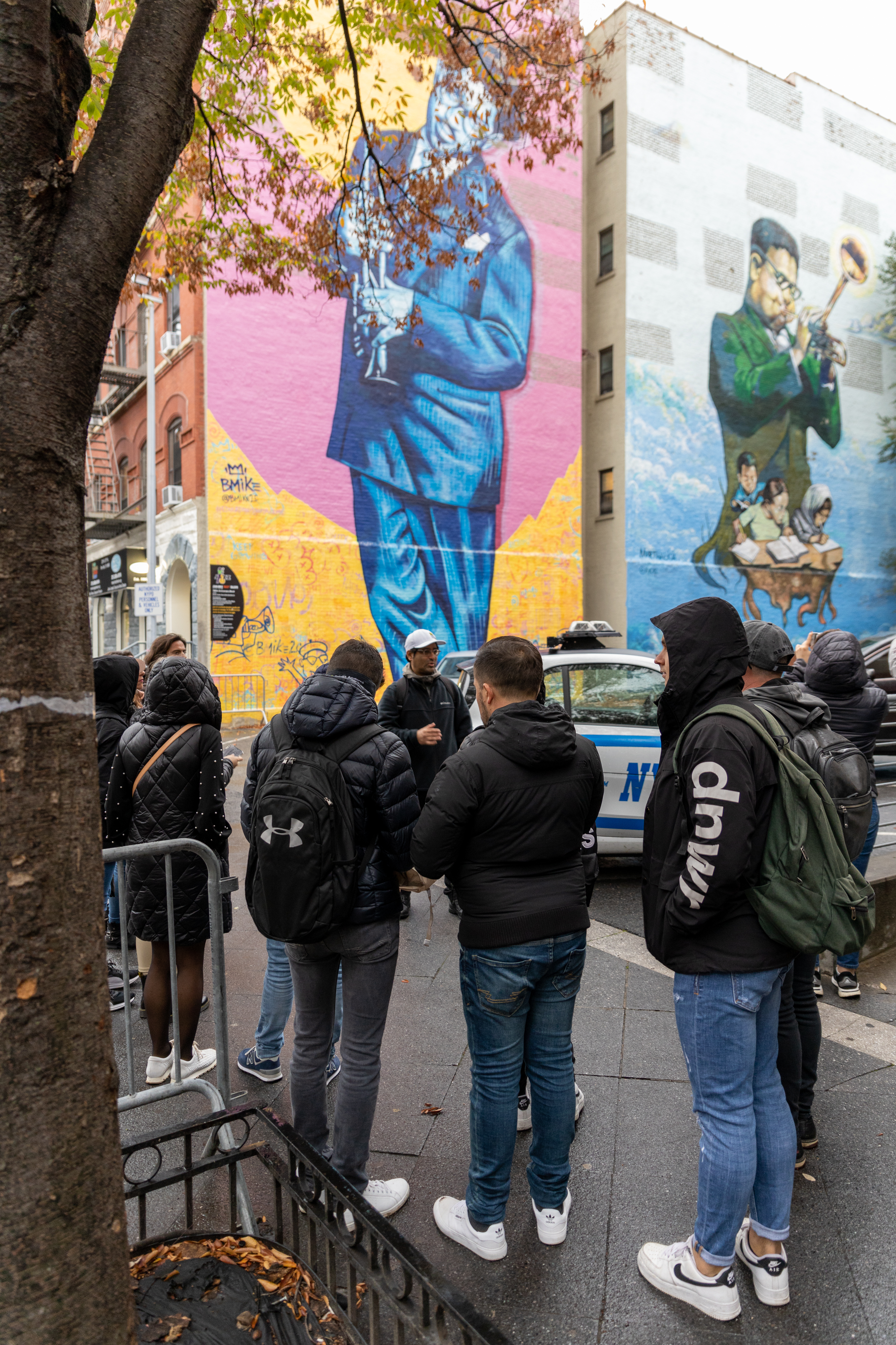 Besuchergruppe mit Guide vor einem Jazz-Wandgemälde in Harlem, New York