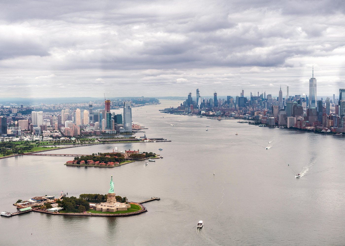 Blick aus der Luft auf die Freiheitsstatue, den Hudson River und die Skyline von Manhattan während eines Helikopterflugs über New York