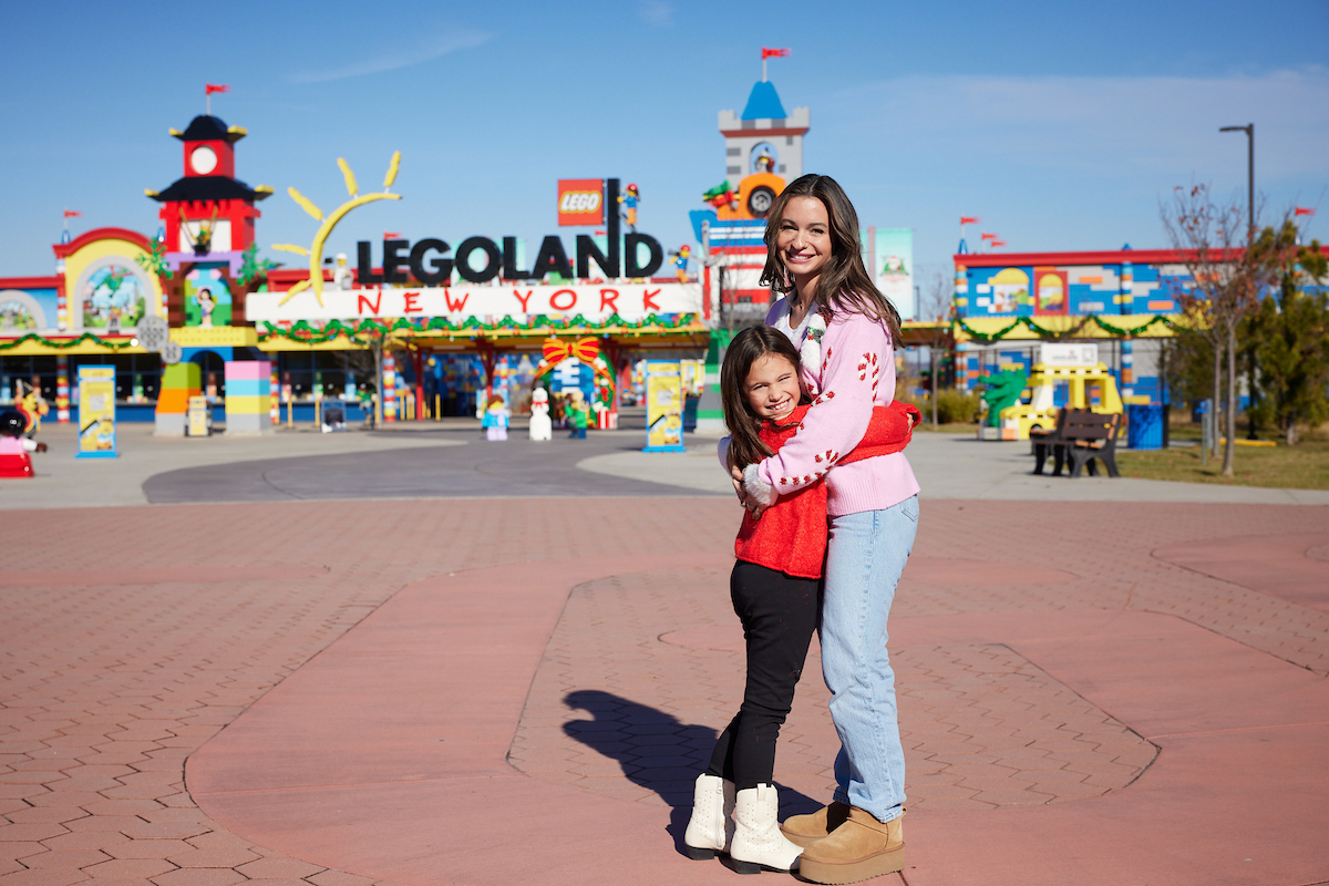 Mutter und Kind vor dem weihnachtlich geschmückten Eingang des LEGOLAND New York Resort