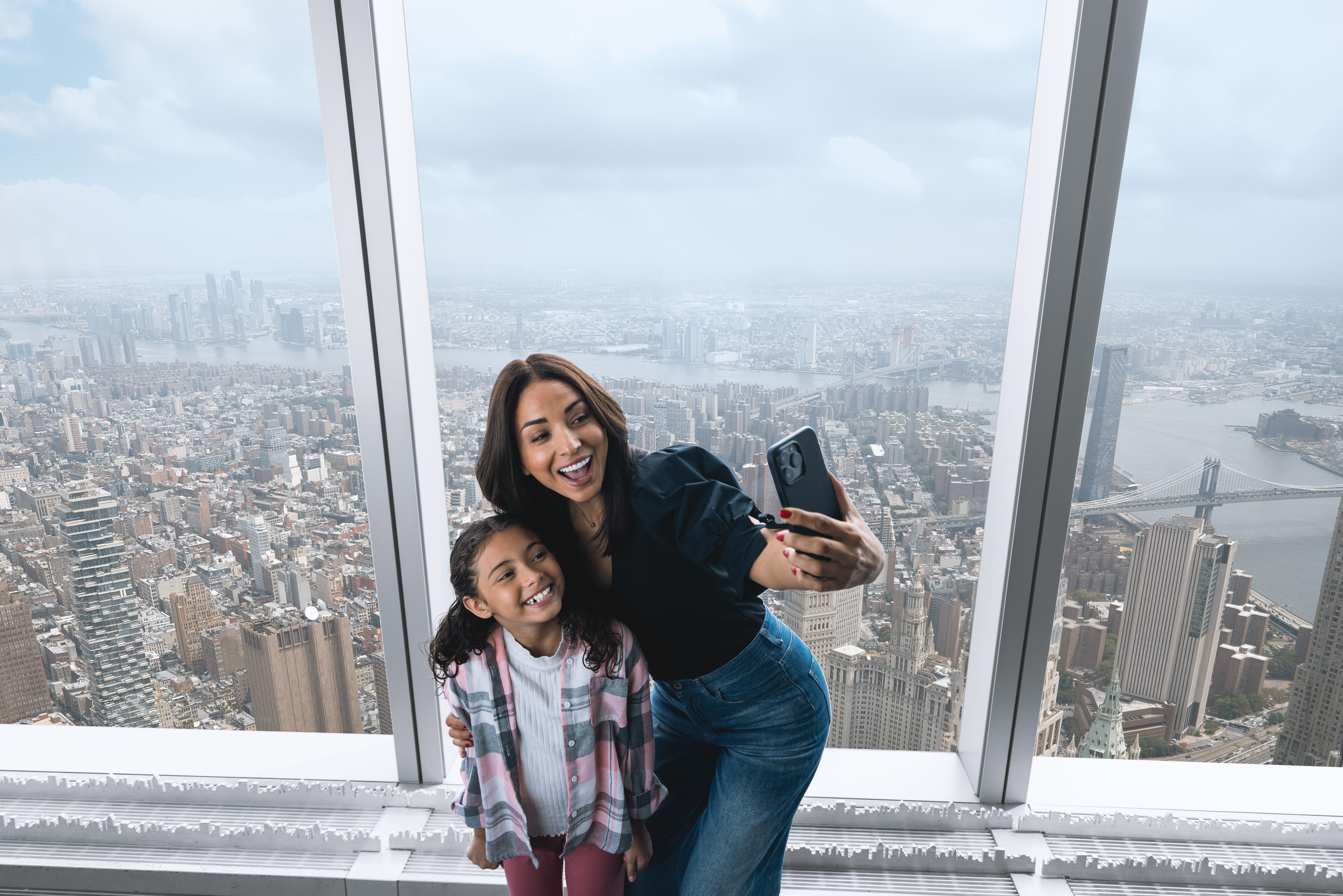 Mutter und Tochter machen ein Selfie im One World Observatory mit Panoramablick über New York
