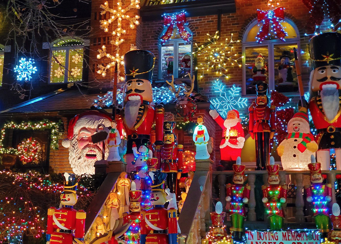 Detailaufnahme einer aufwendigen Weihnachtsdekoration mit großen Nussknackern, Weihnachtsmann und leuchtenden Schneeflocken.