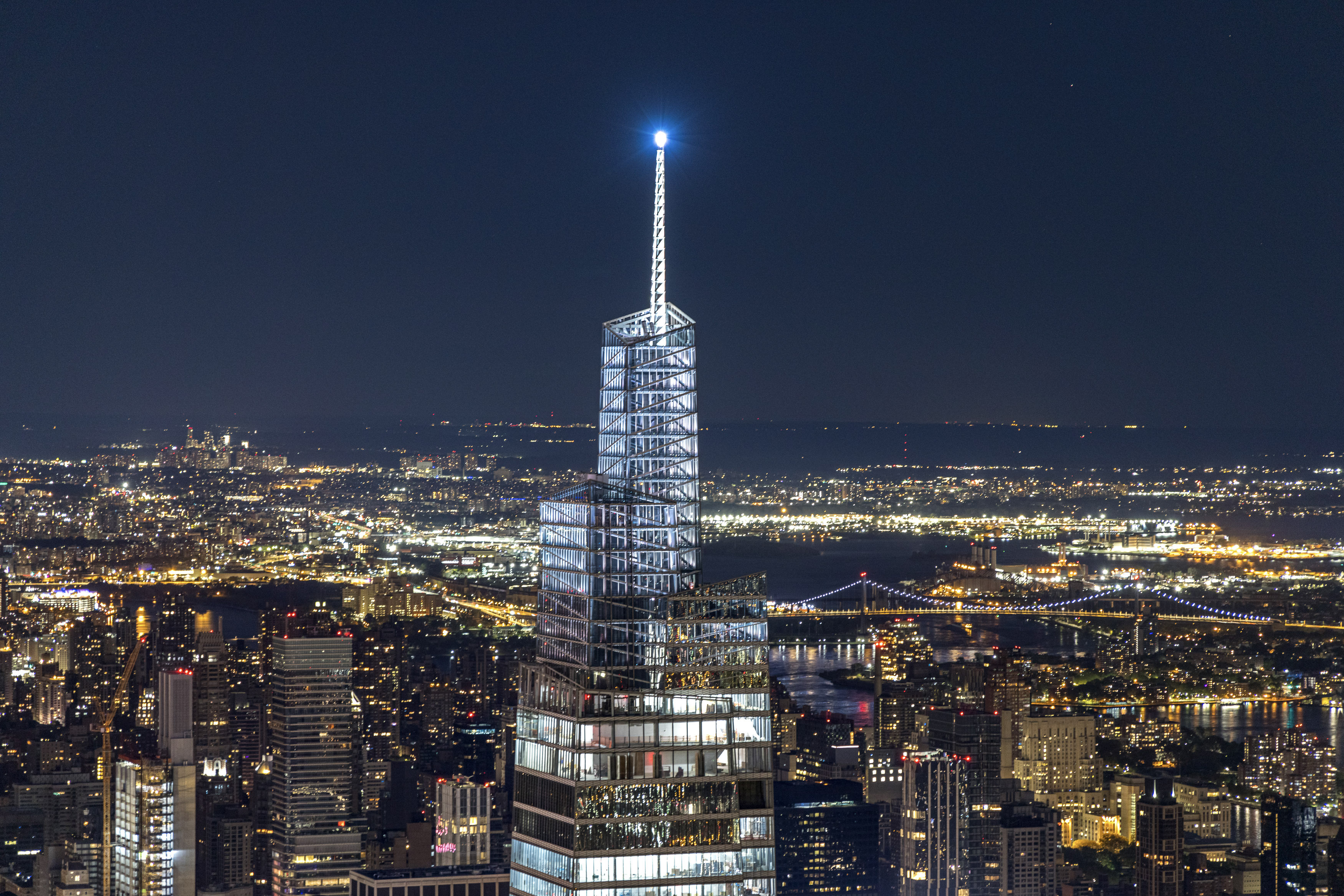 Beleuchtete Spitze des One Vanderbilt bei Nacht mit Blick über Manhattan