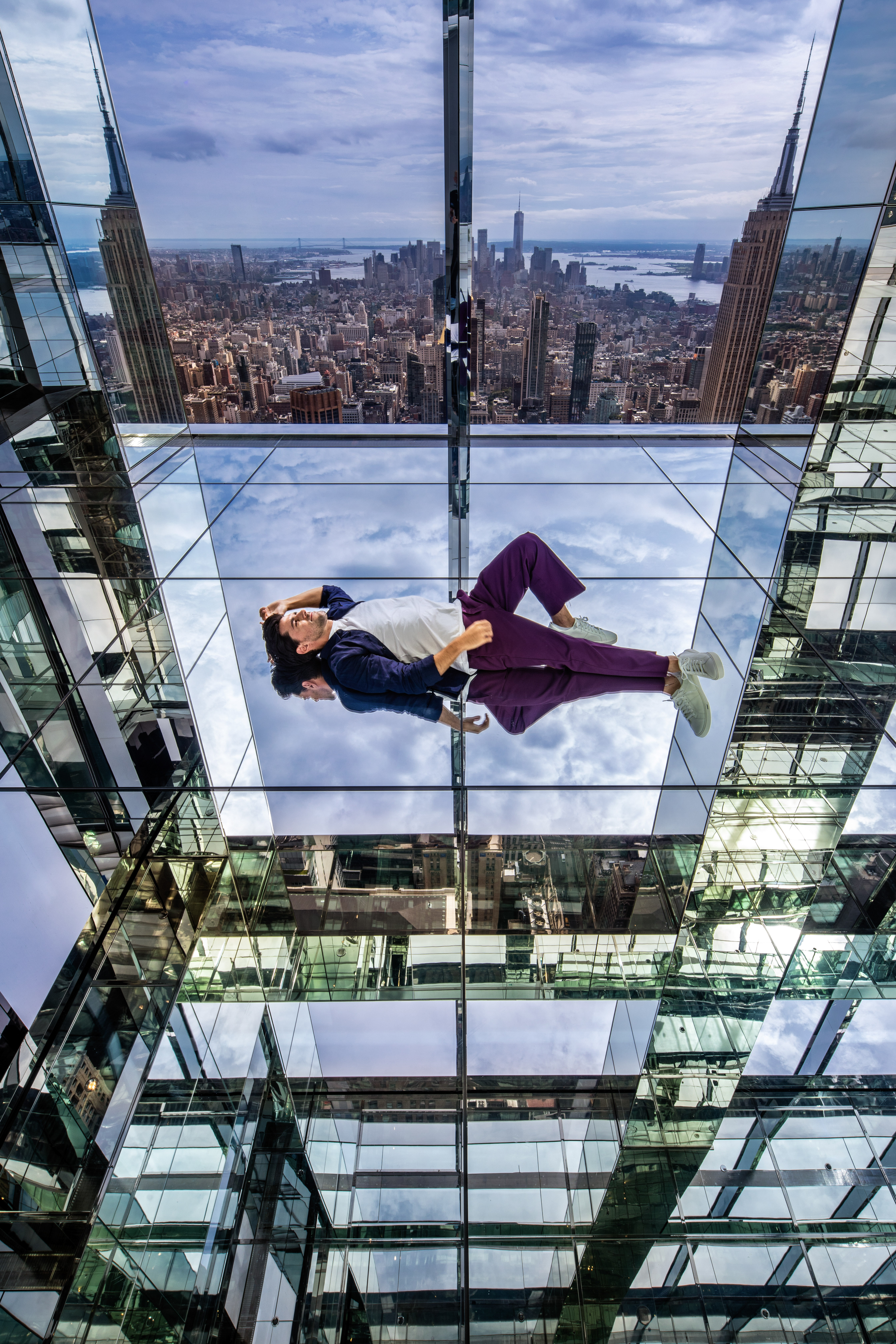 Besucher im verspiegelten Transcendence Erlebnisraum des SUMMIT One Vanderbilt mit Blick auf das Empire State Building