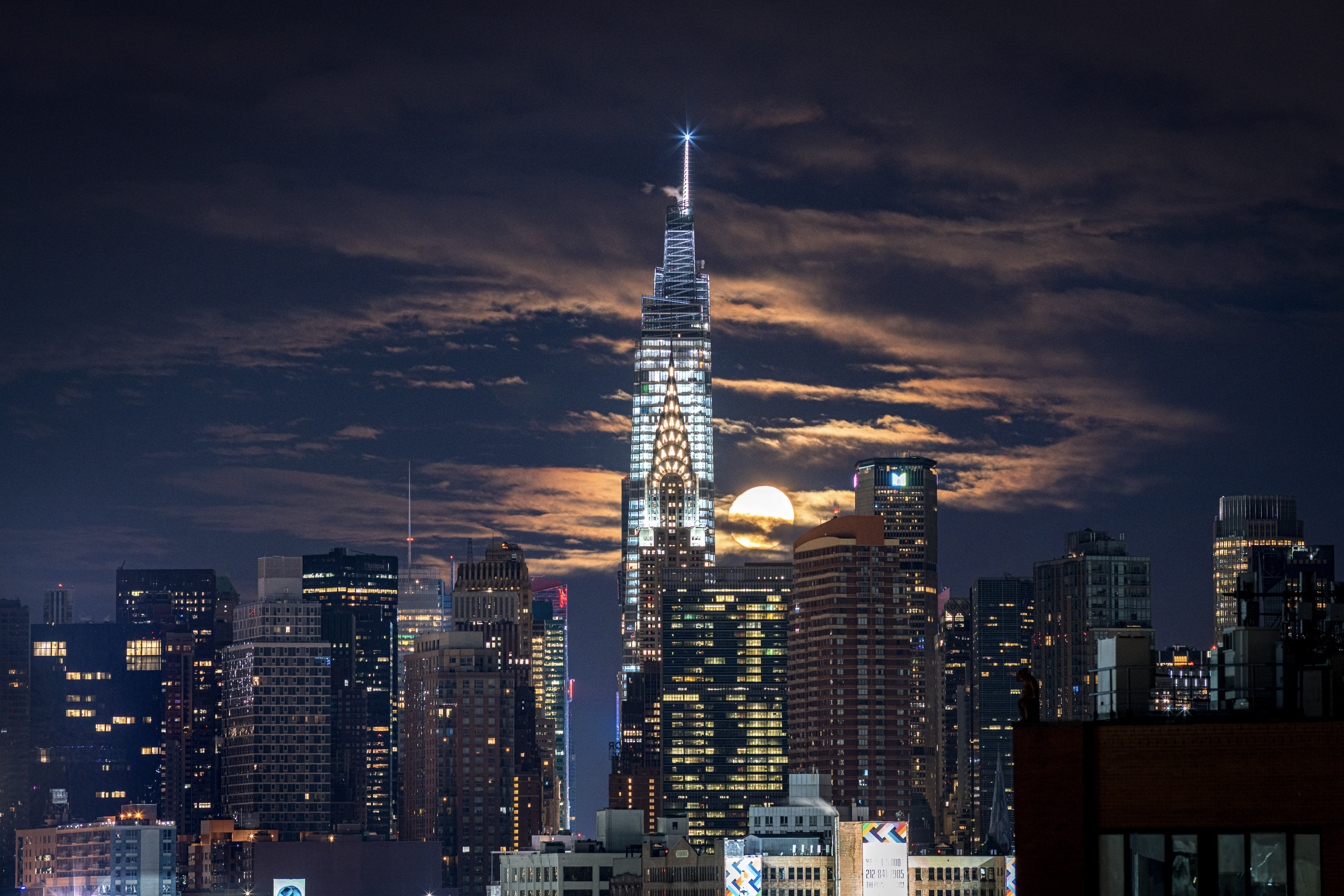 One Vanderbilt bei Nacht mit beleuchteter Spitze und Mond über der Skyline von New York