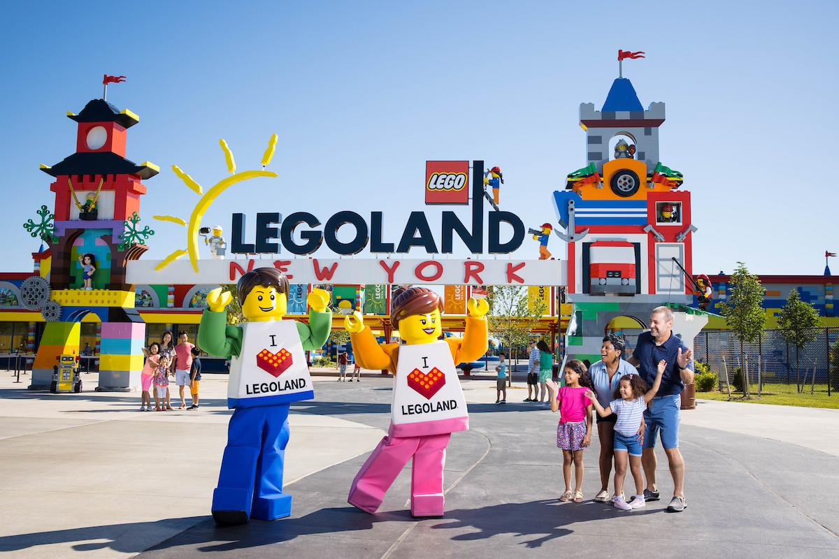 Familie mit großen LEGO Figuren vor dem farbenfrohen Eingang des LEGOLAND New York Resort