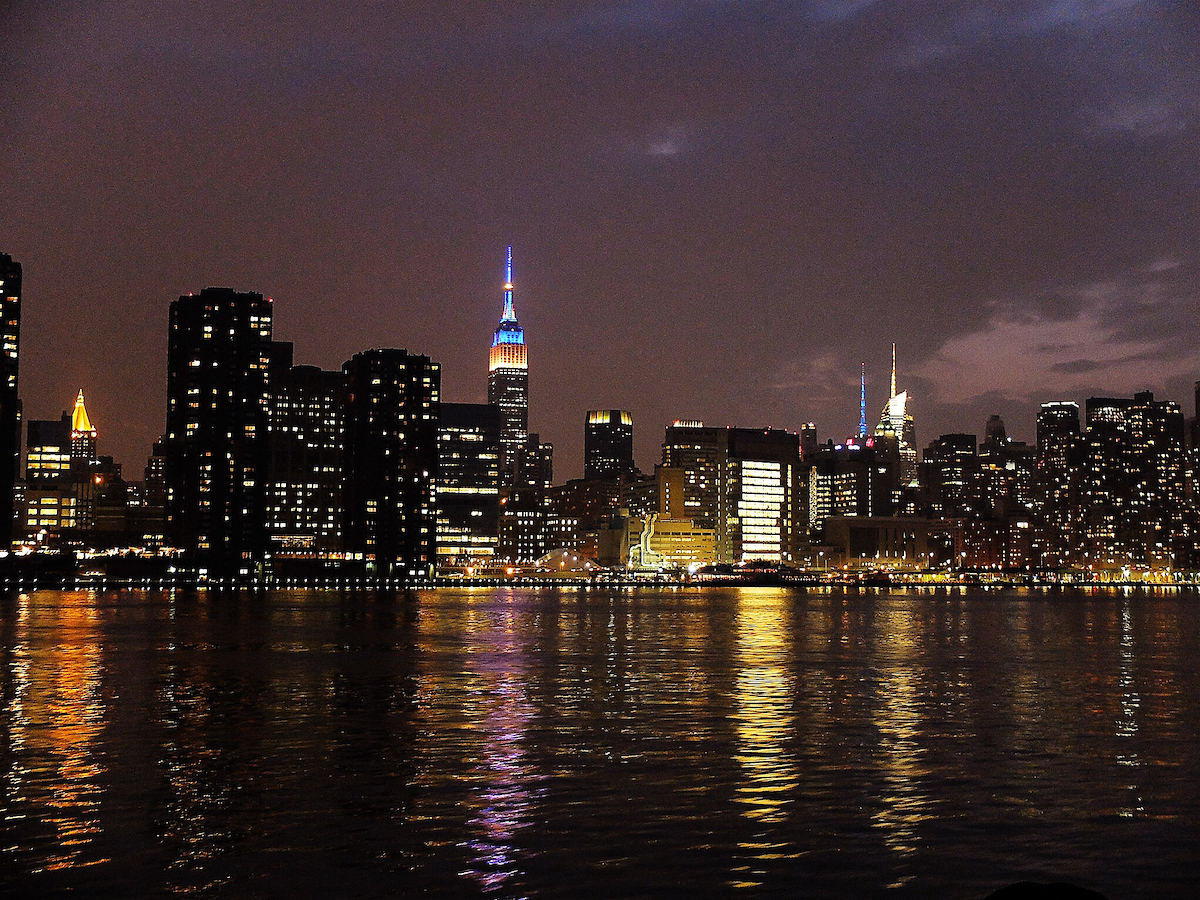 Empire State Building nachts beleuchtet über der Skyline von Midtown Manhattan