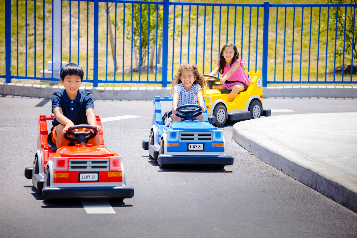 Kinder fahren in bunten LEGO Autos auf einer Fahrstrecke im LEGOLAND New York Resort