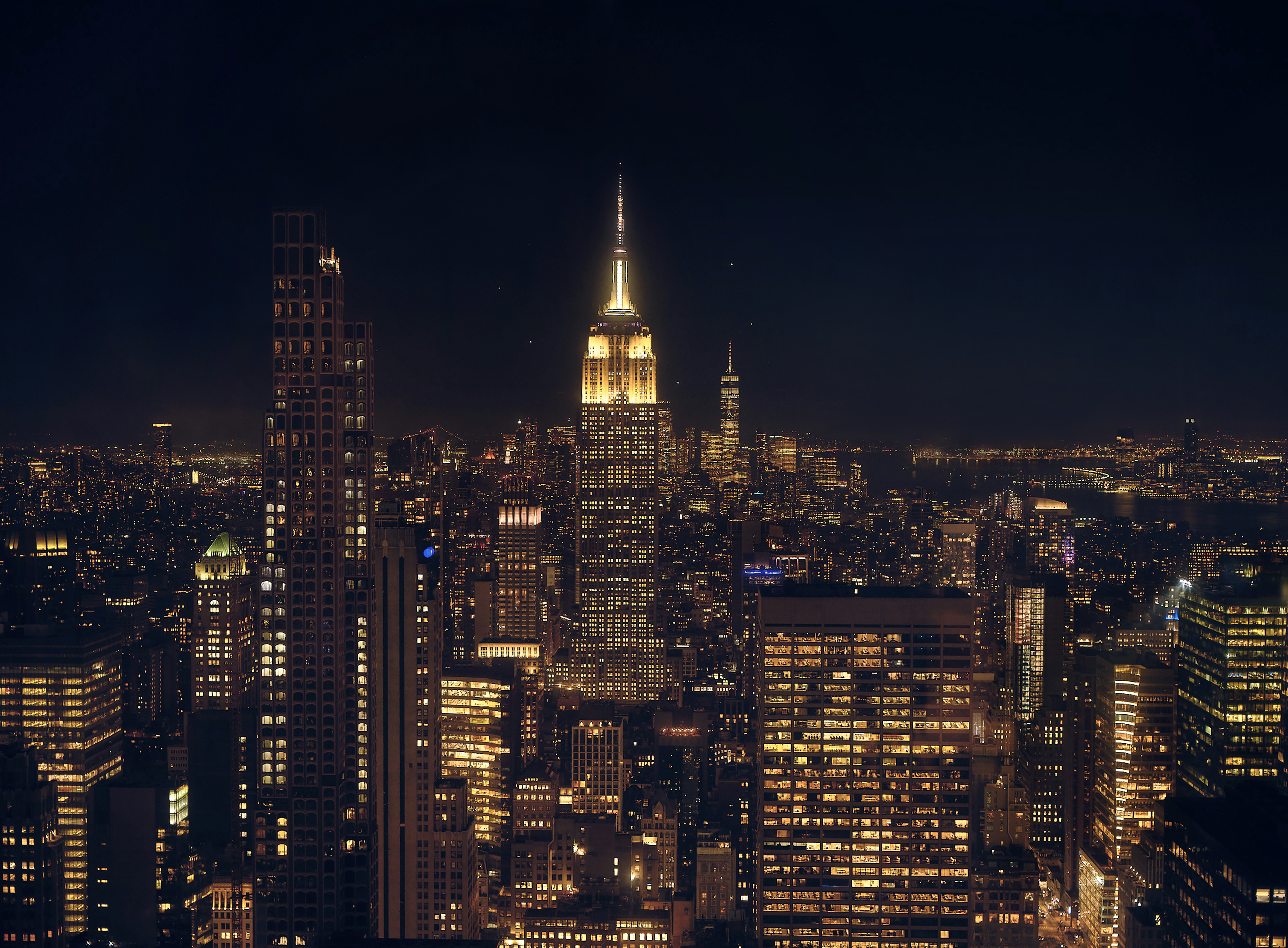 Nächtlicher Blick vom Top of the Rock auf das beleuchtete Empire State Building und die Skyline von Manhattan