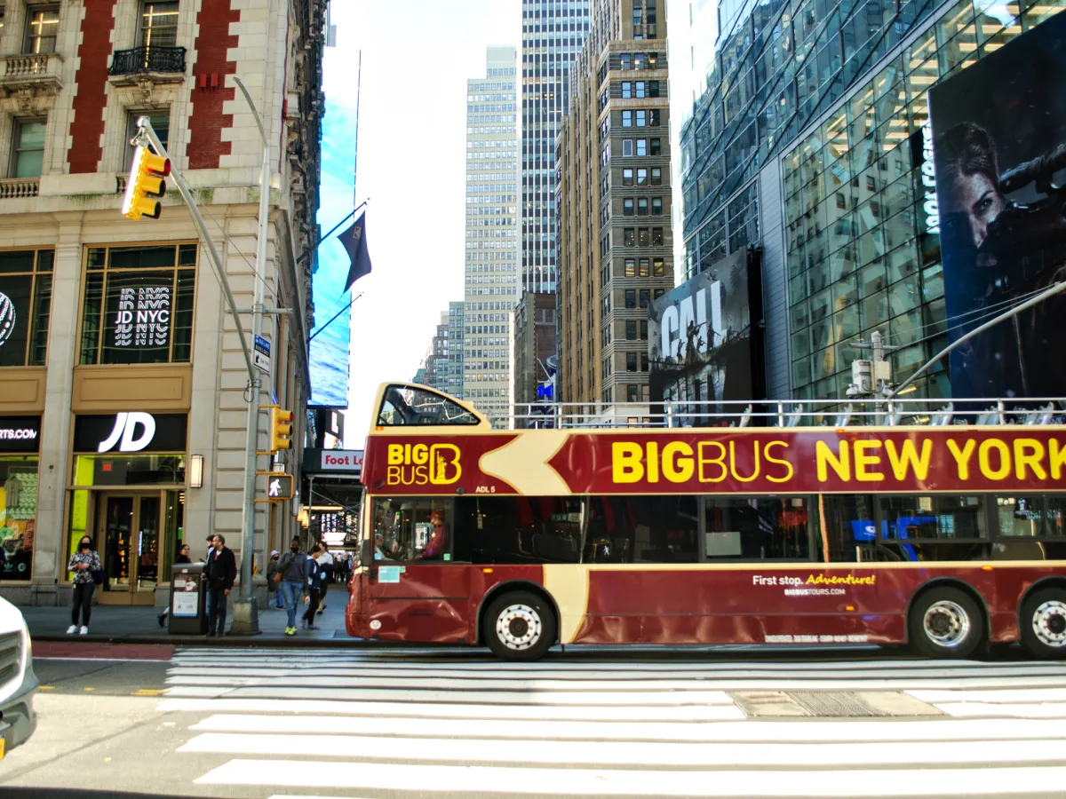 Big-Bus-New-York-Doppeldeckerbus fährt an einer belebten Straßenkreuzung in Manhattan vorbei