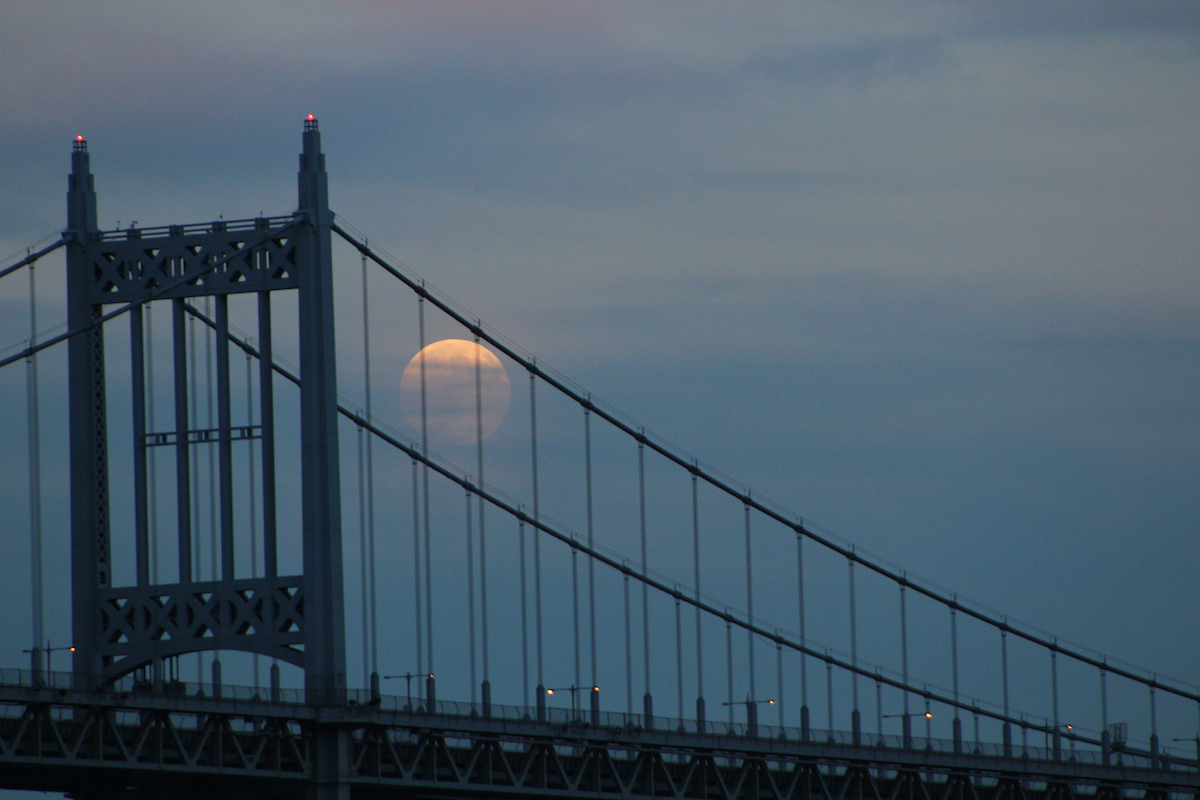 Vollmond hinter einer Hängebrücke in New York bei Abenddämmerung