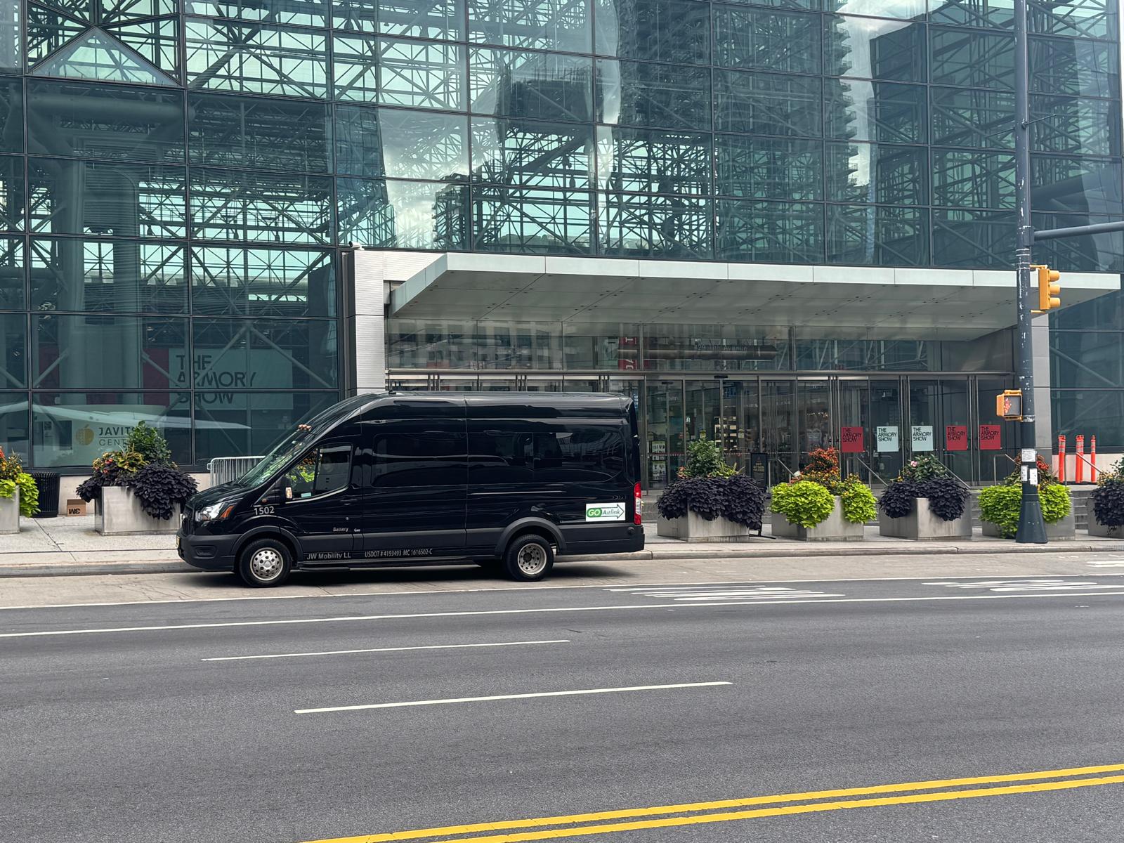 GO Airlink Shuttle-Van fährt an der verglasten Fassade des Javits Center in Manhattan vorbei
