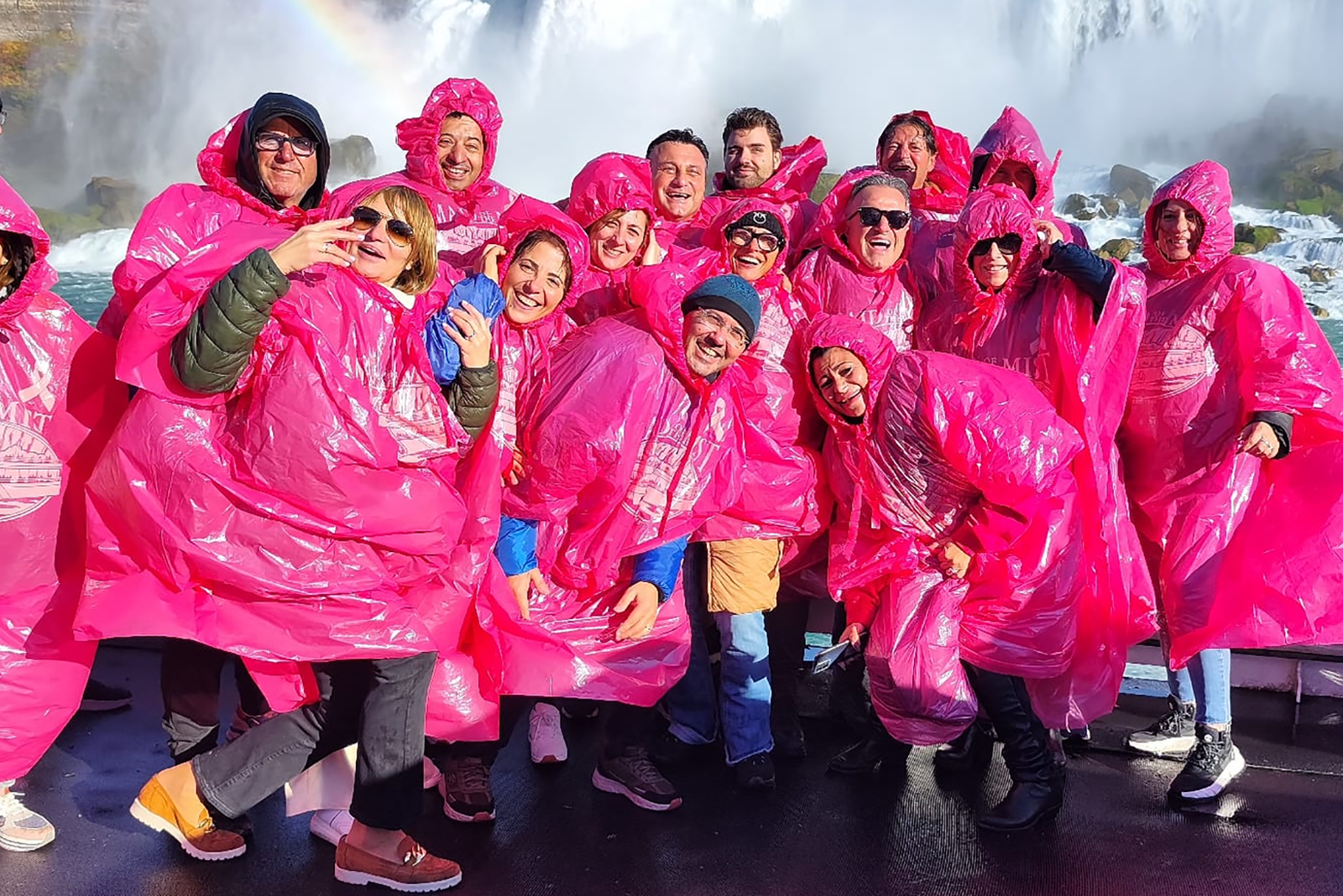 Reisegruppe mit Regenponchos bei einer Bootstour direkt an den Niagarafällen