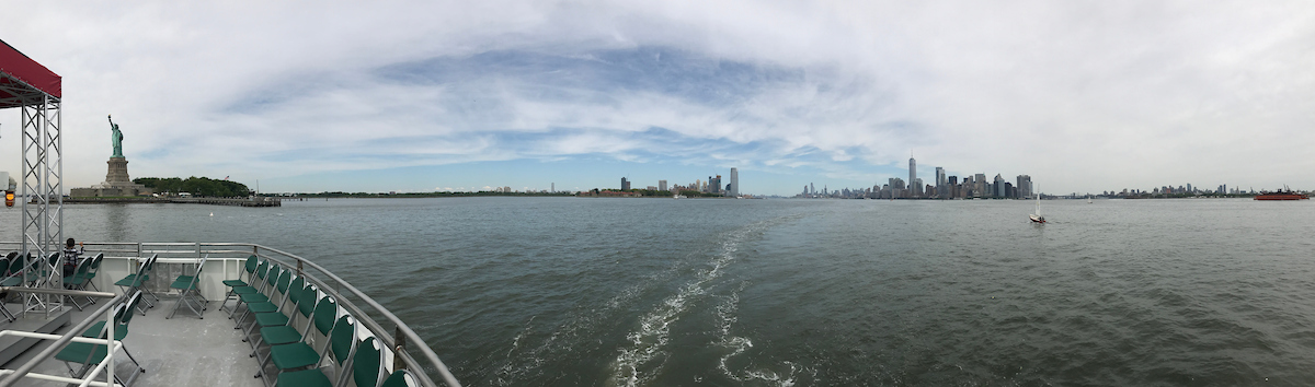 Panoramablick vom Bootsdeck auf die Freiheitsstatue und die Skyline von New York