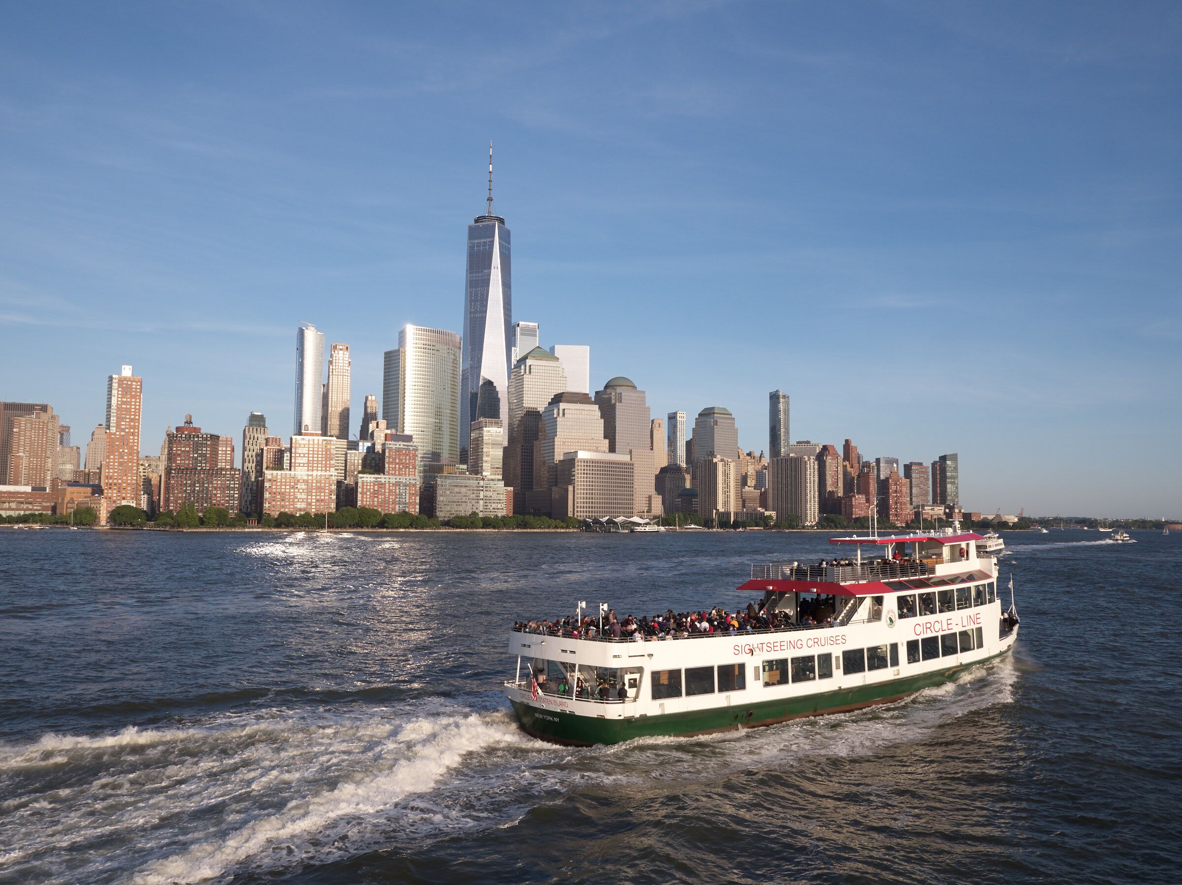 Circle Line Sightseeing Schiff auf dem Hudson River vor der Skyline von Lower Manhattan und dem One World Trade Center