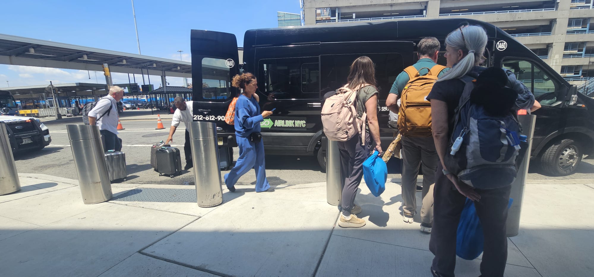 Fahrgäste warten mit Koffern vor dem GO Airlink Van am Terminal des JFK International Airport