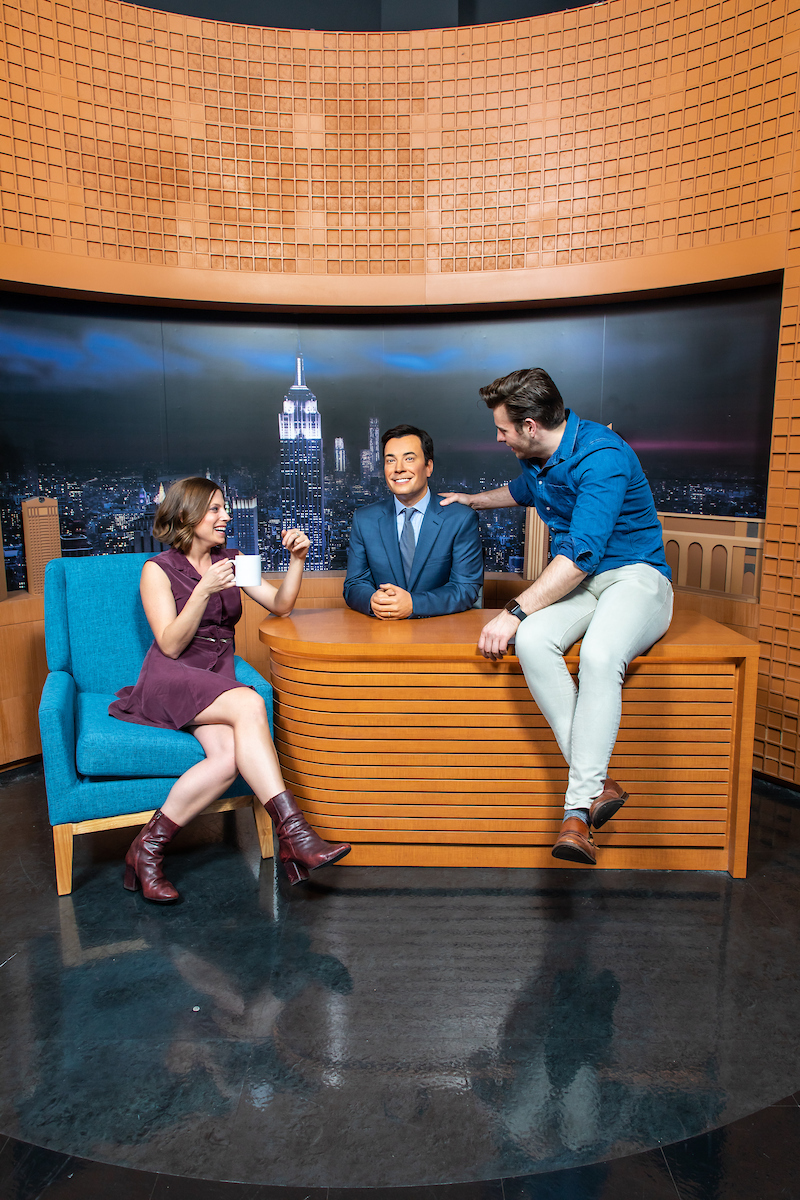 Besucher posieren am Tonight Show Schreibtisch mit der Jimmy Fallon Wachsfigur bei Madame Tussauds New York