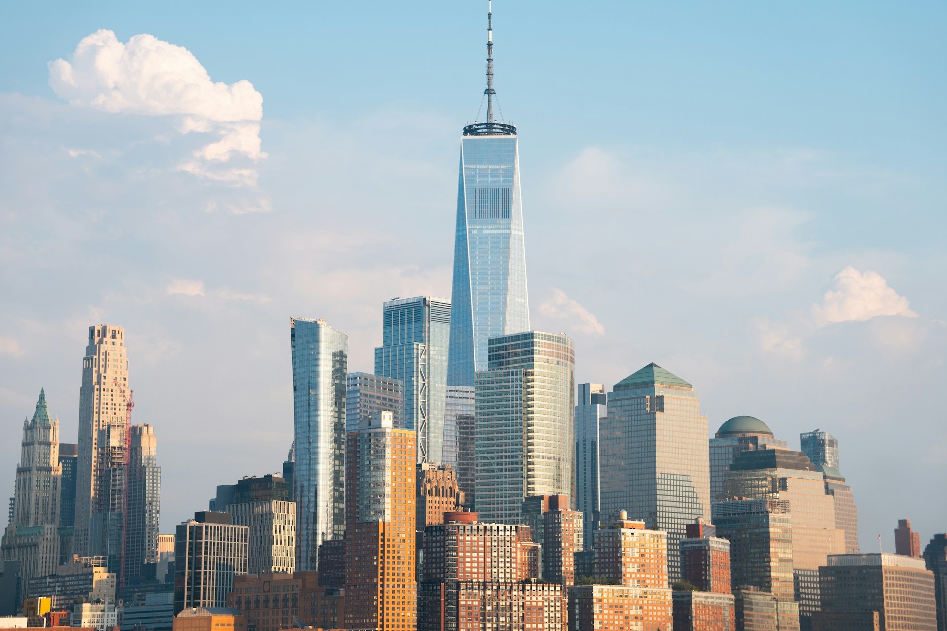One World Trade Center mit der Skyline von Lower Manhattan in New York bei blauem Himmel