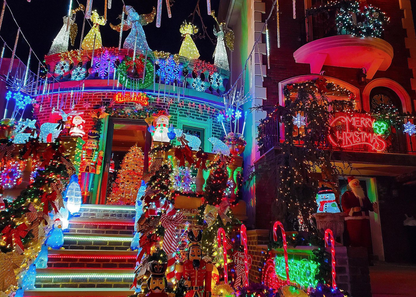 Üppig geschmückter Hauseingang in Brooklyn mit beleuchteten Nussknackern, Weihnachtsmännern und Lichterketten.