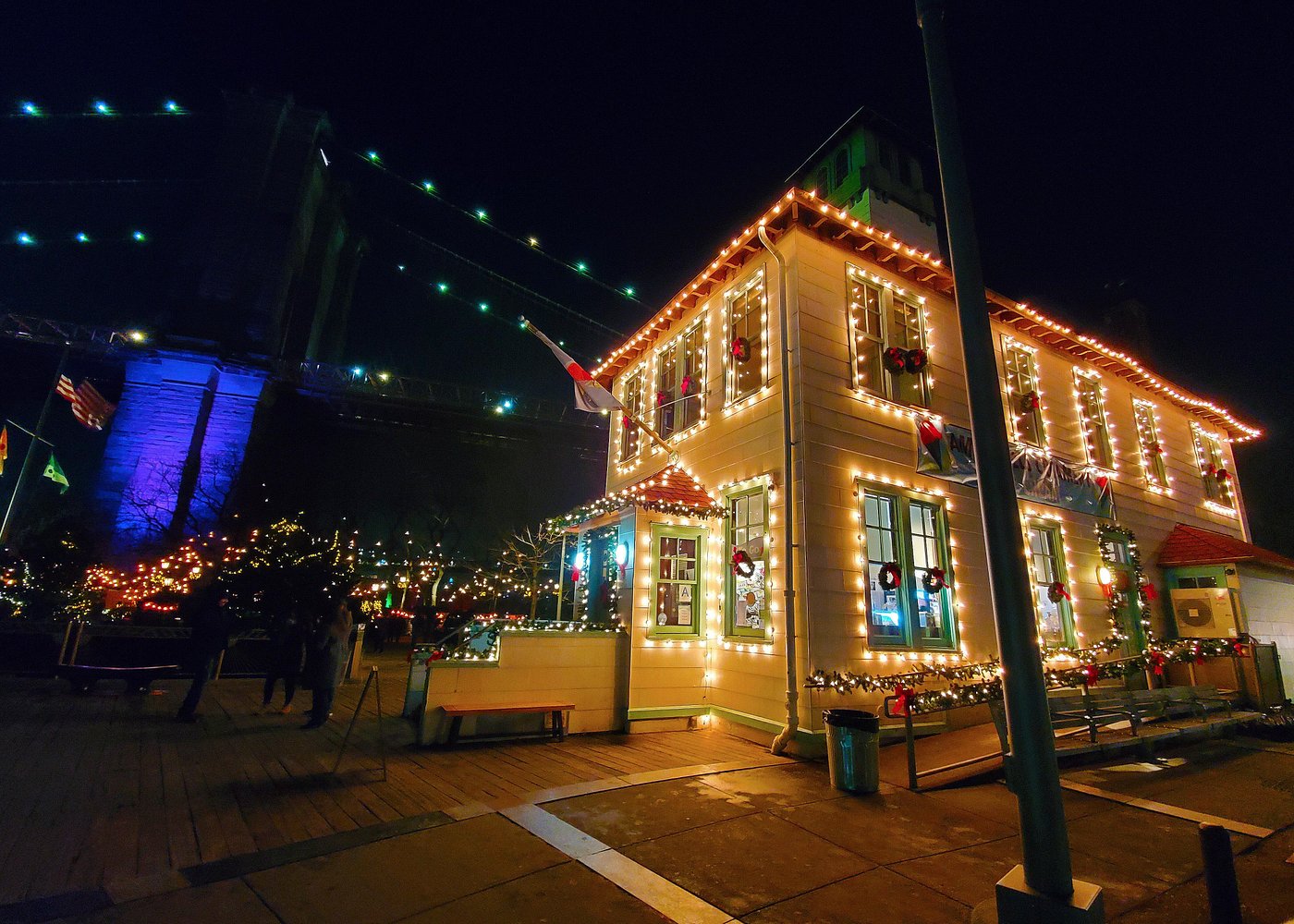 Weihnachtlich geschmücktes Haus mit Lichterketten und Adventskränzen nahe der Brooklyn Bridge in New York.