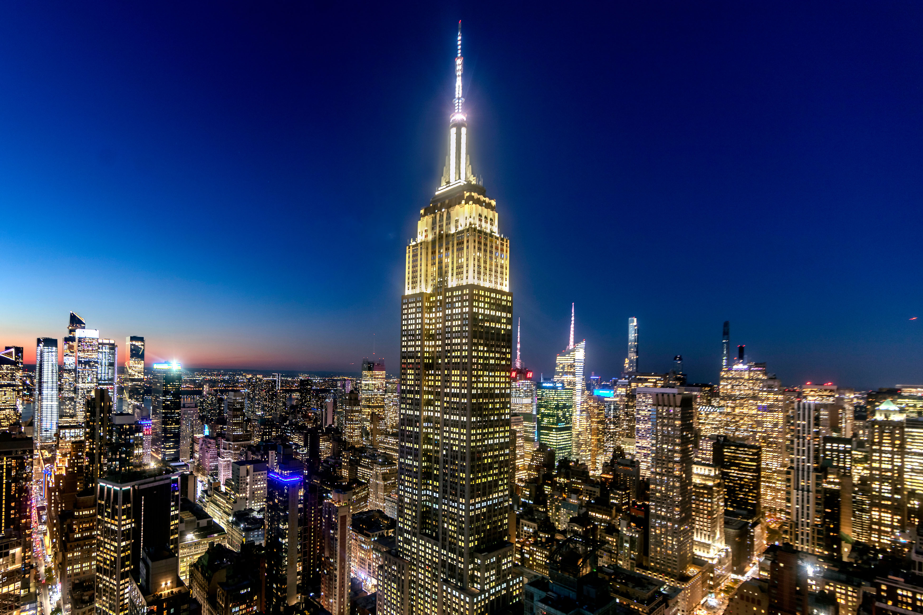 Beleuchtetes Empire State Building und die Skyline von Manhattan bei Nacht
