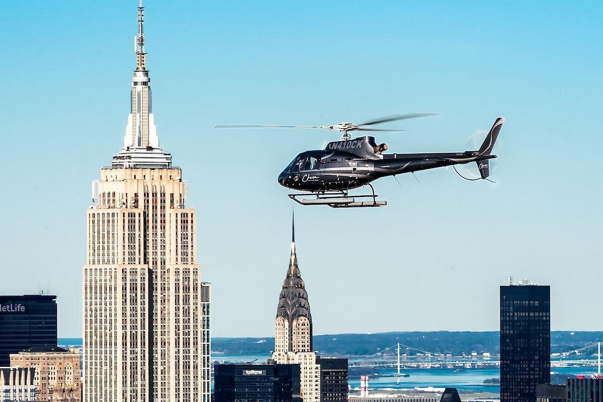 Schwarzer Helikopter vor dem Empire State Building und dem Chrysler Building bei einem Rundflug über New York