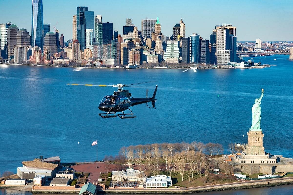 Helikopter über dem New Yorker Hafen mit Freiheitsstatue und Skyline von Lower Manhattan im Hintergrund