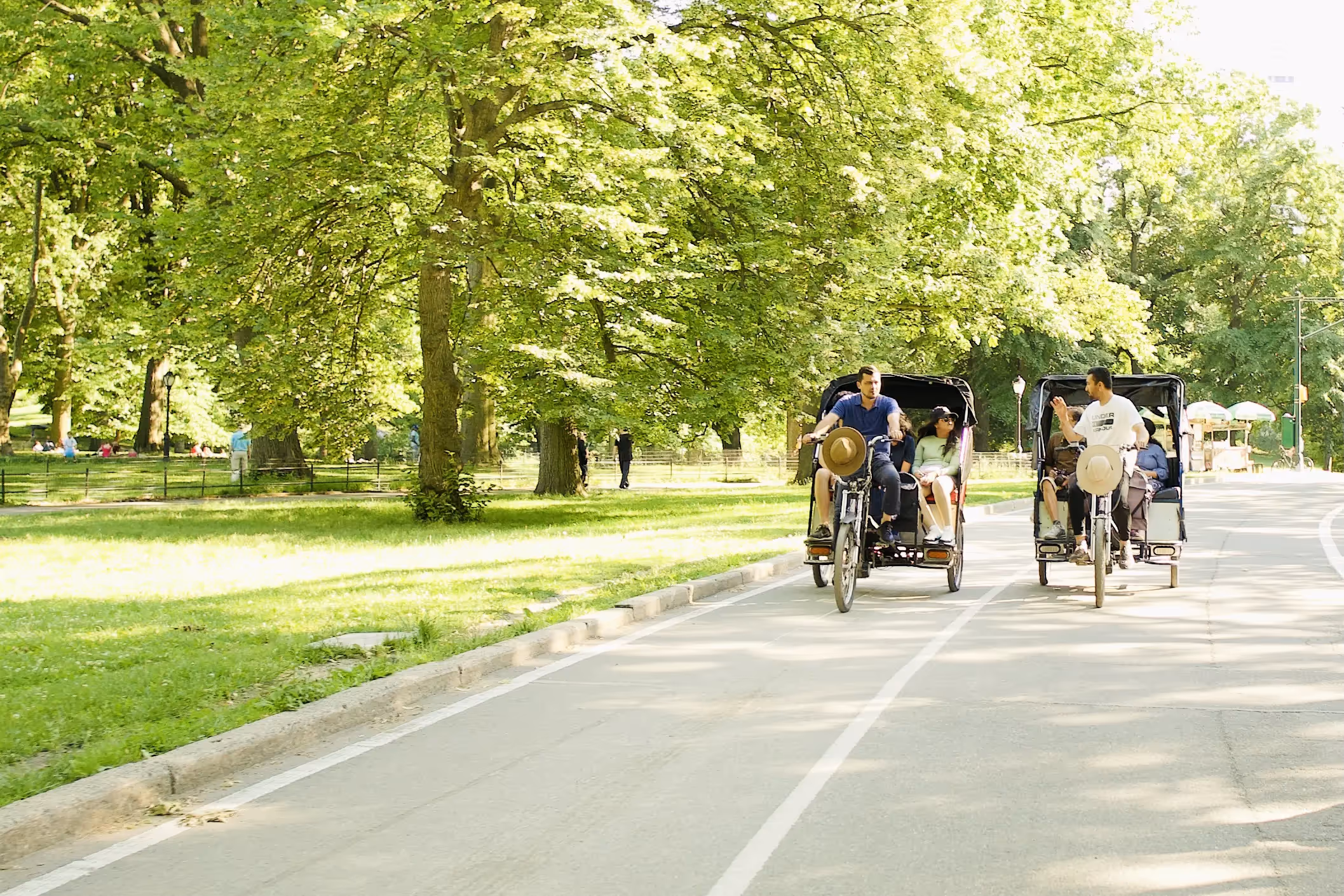Pedicab-Fahrer mit Passagieren auf schattigem Weg im Central Park im Sommer