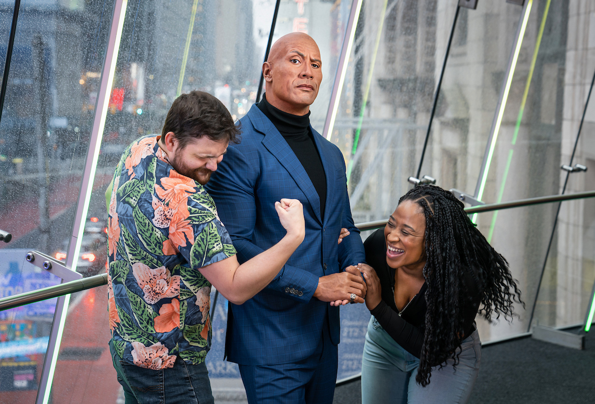 Besucher posieren mit der Wachsfigur von Dwayne The Rock Johnson bei Madame Tussauds New York