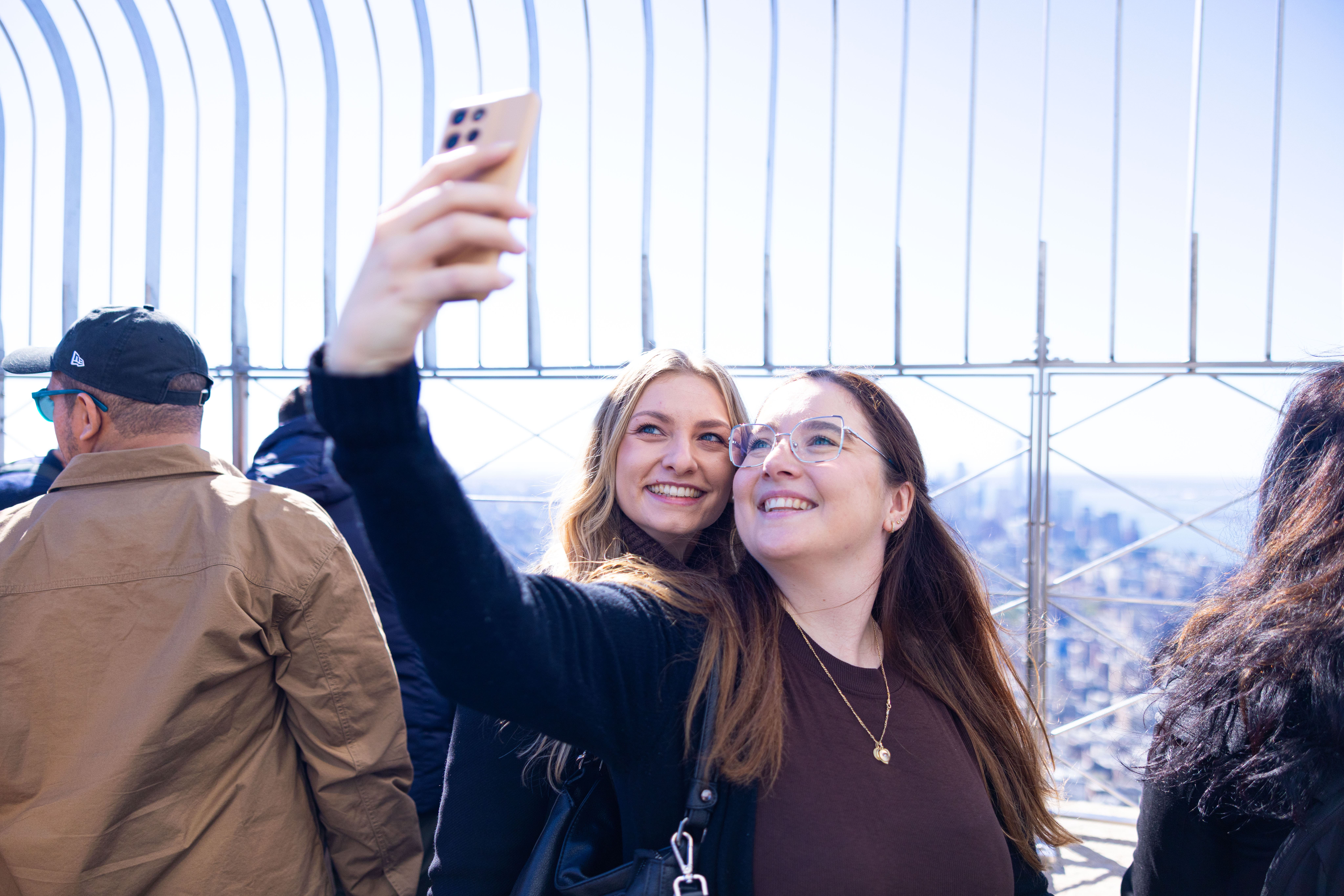 Zwei Besucherinnen machen ein Selfie auf der Aussichtsplattform des Empire State Buildings